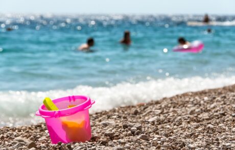 Žnjan pebble beach in Split with a people swimming in the sea.